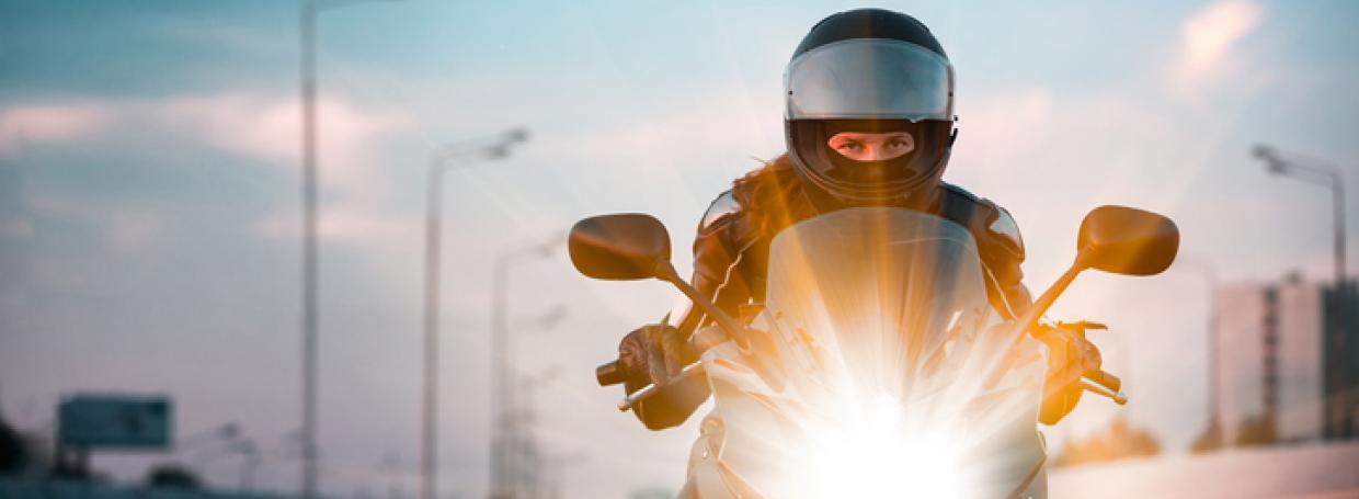 Woman drives on a motorcycle on a morning highwaymorocycklist racing on a morning city background